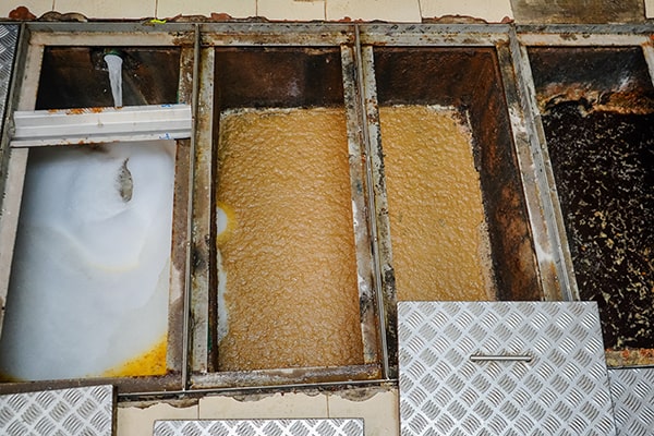 foul odors, slow drainage, and visible grease accumulation are all signs that grease trap maintenance is needed